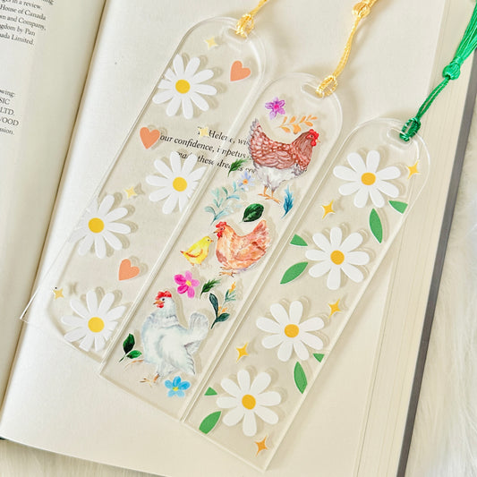 Decorative bookmarks with floral and chicken designs on an open book.