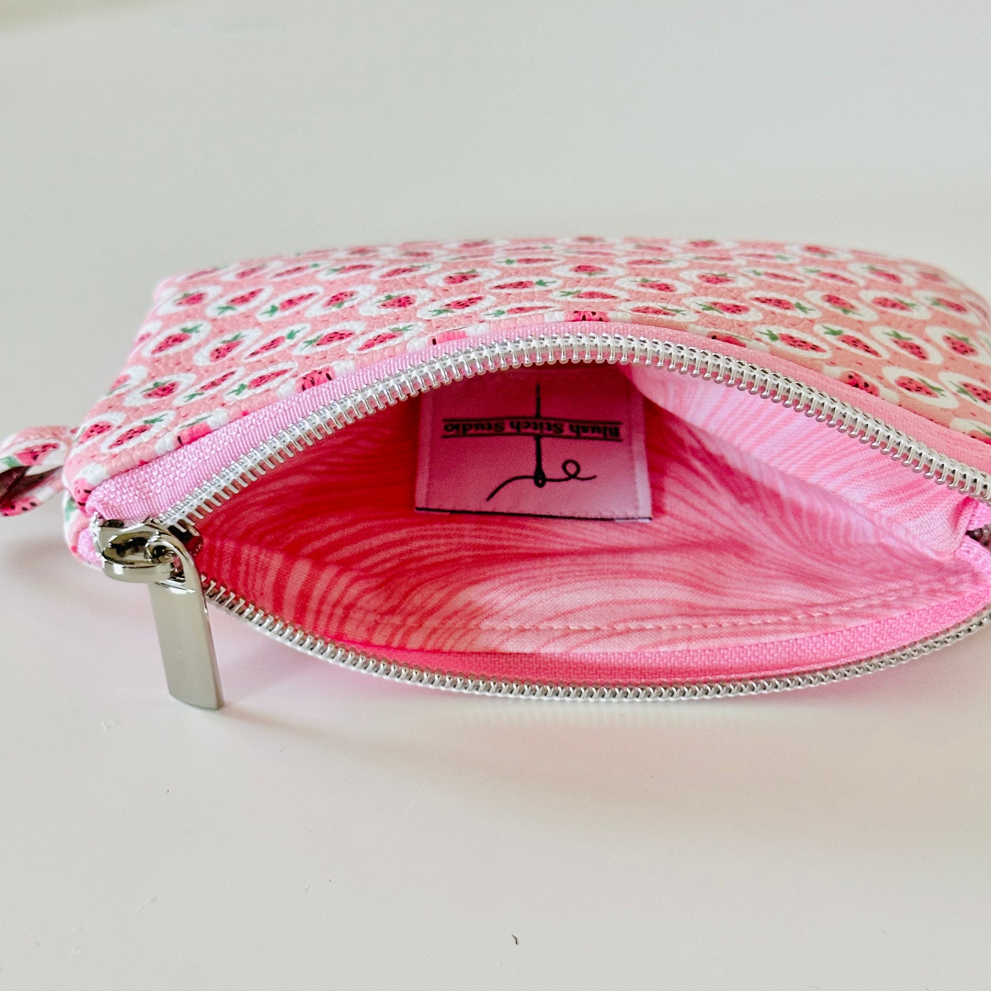 Pink strawberry coin purse on a white background