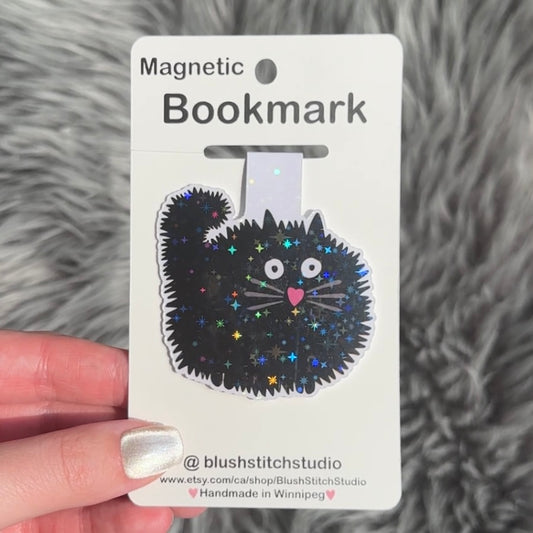 black  cat bookmark on an open book