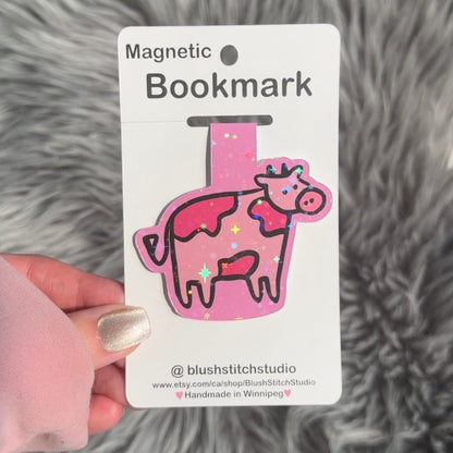 Pink cow-shaped magnetic bookmark on a Blush Stitch Studio card against a gray fur background