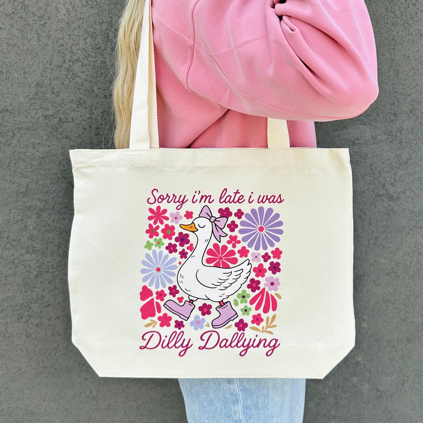 Tote bag with a sorry im late i was dilly dallying goose graphic and text on a gray background