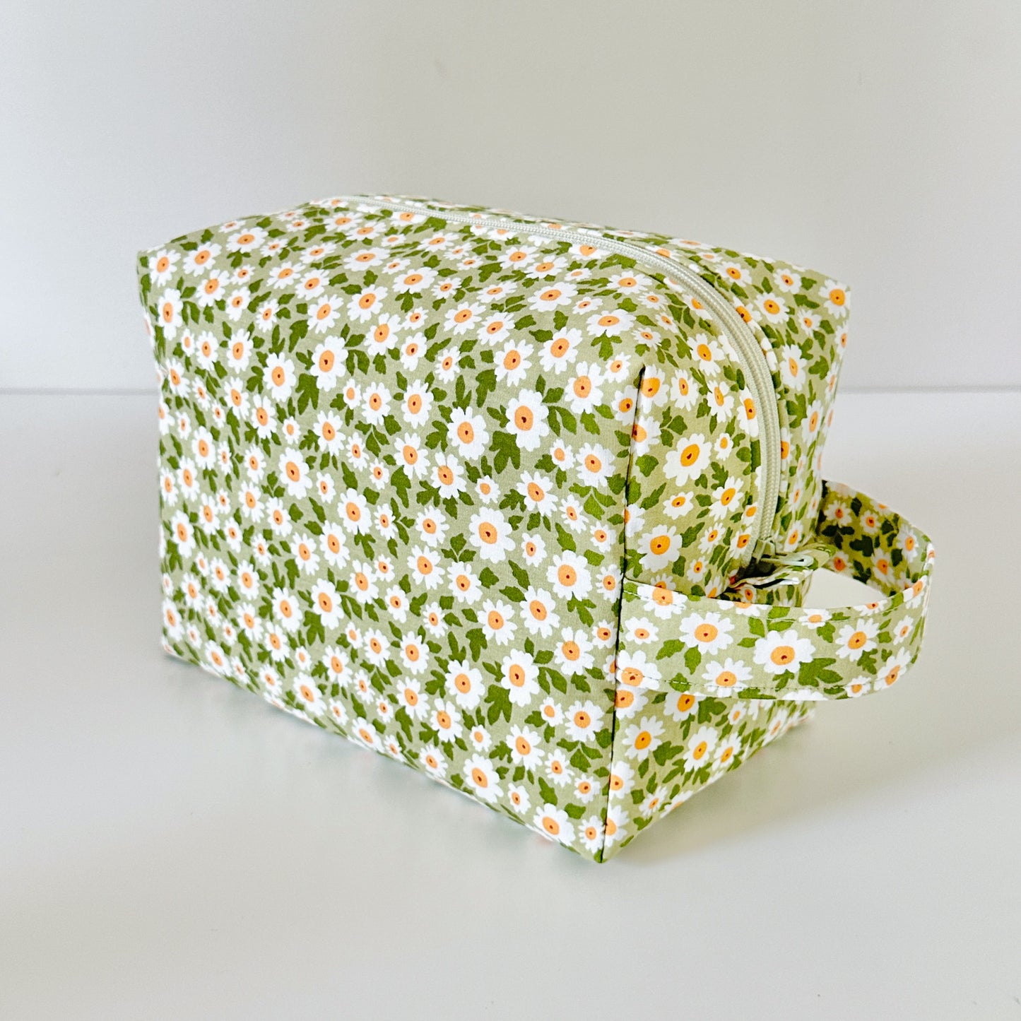 Floral-patterned cosmetic bag on a white background