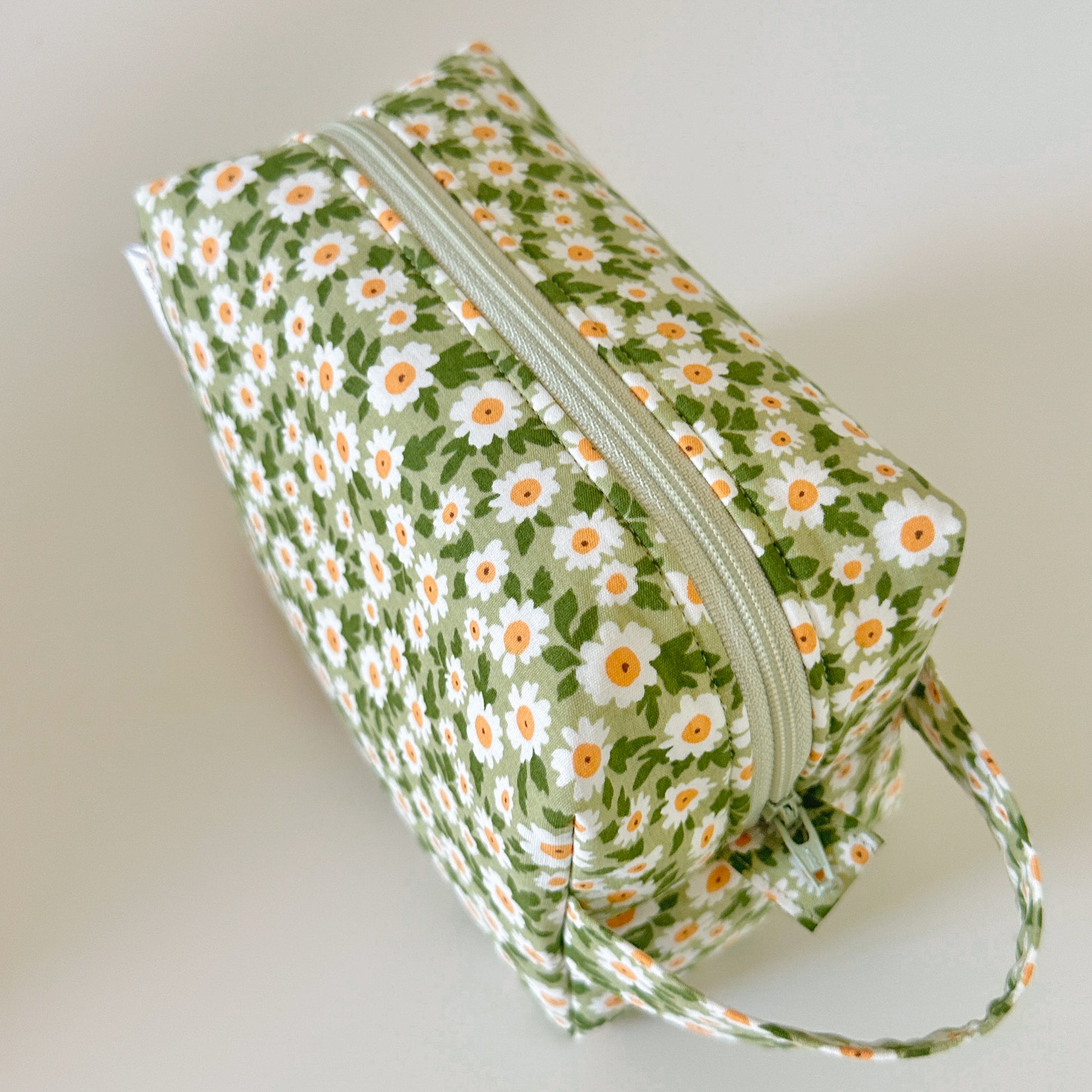 Floral-patterned pouch with a zipper on a light background