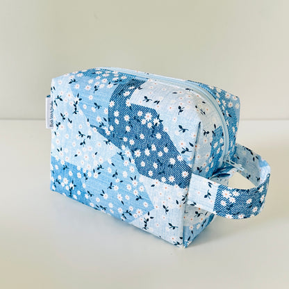 Blue floral patterned cosmetic bag on a light background