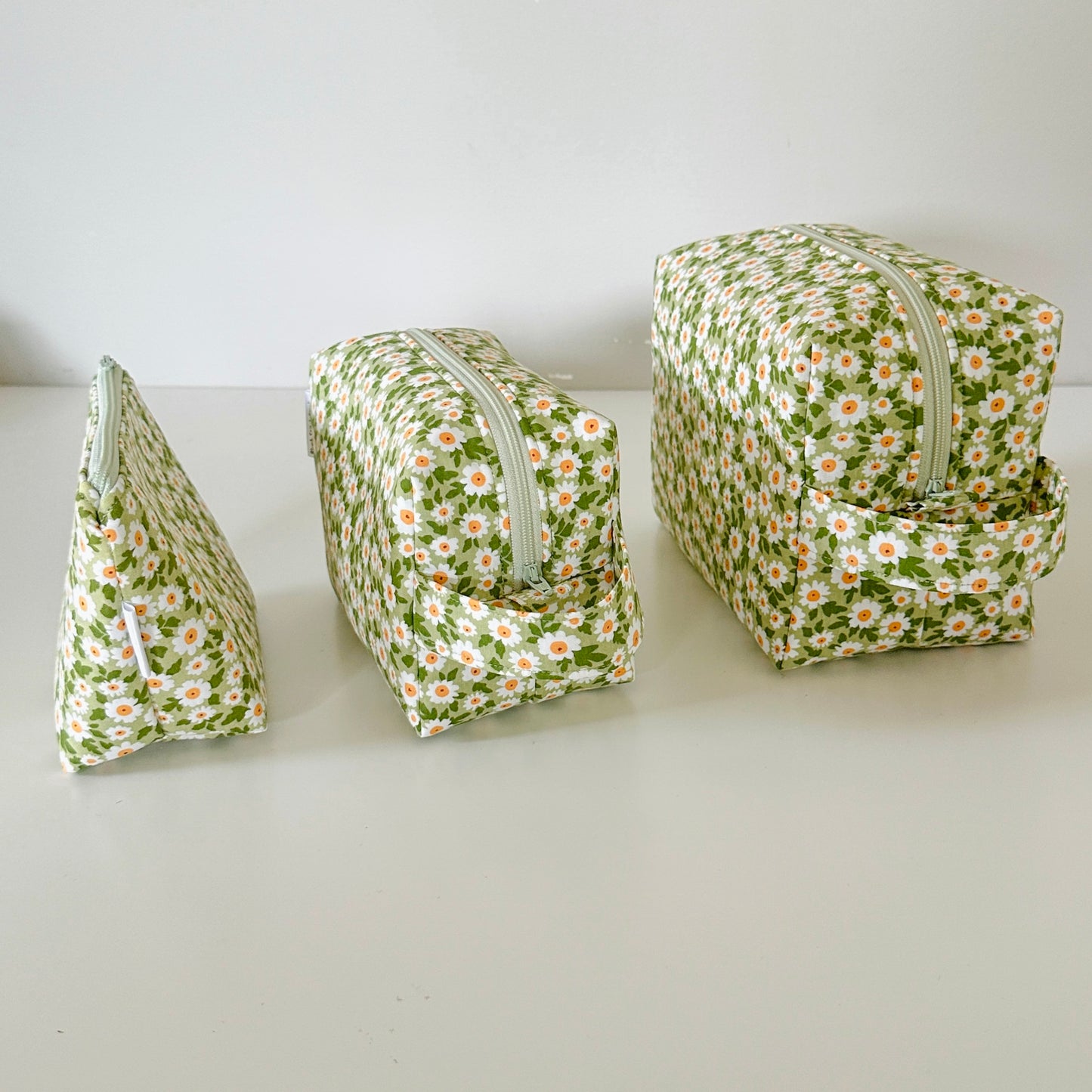 Three floral-patterned pouches on a white surface