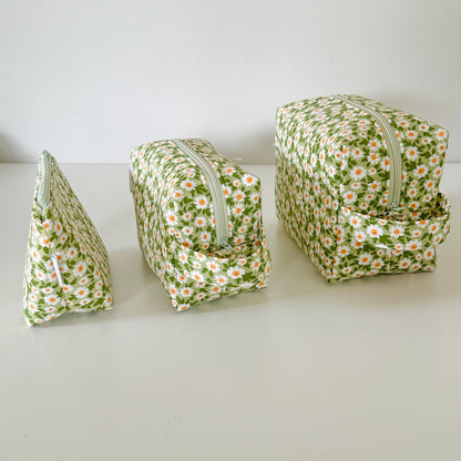 Three floral-patterned pouches on a white surface