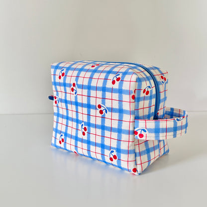 Plaid toiletry bag with cherry pattern on a white background