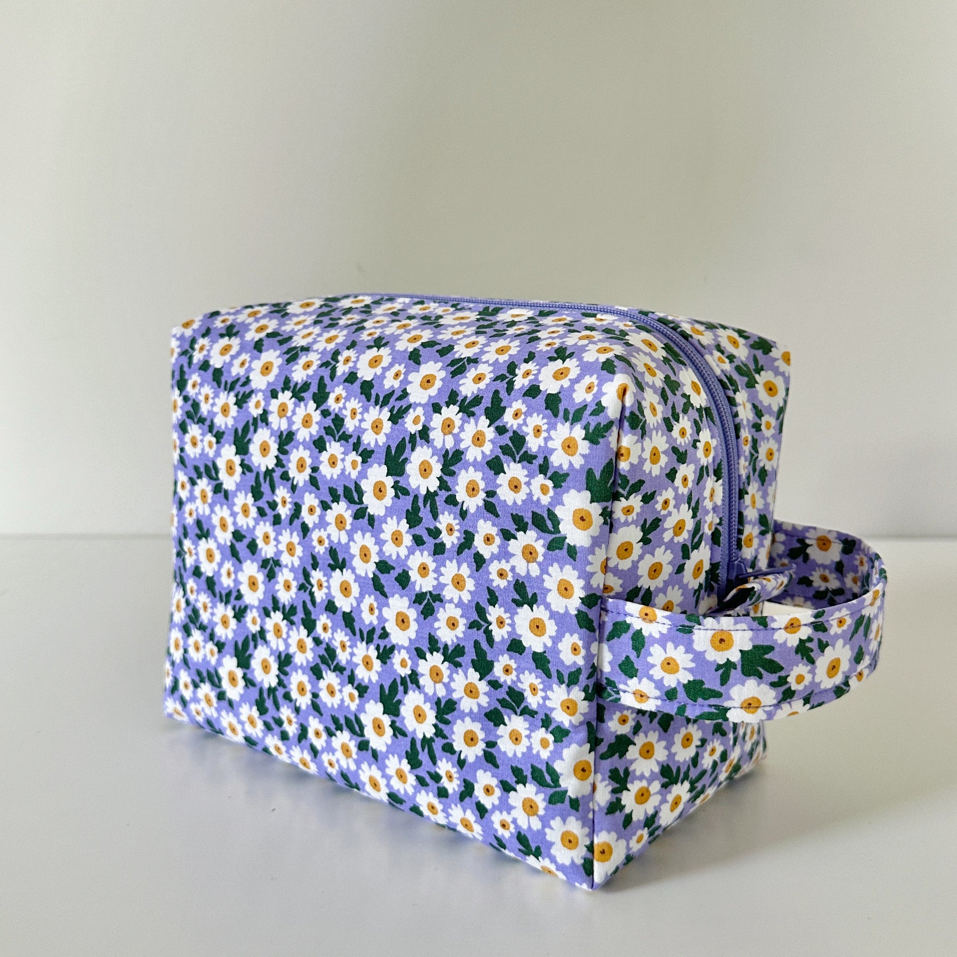 Floral-patterned toiletry bag on a light gray background