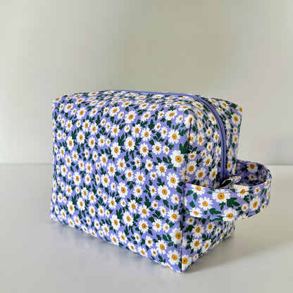 Floral-patterned toiletry bag on a light gray background