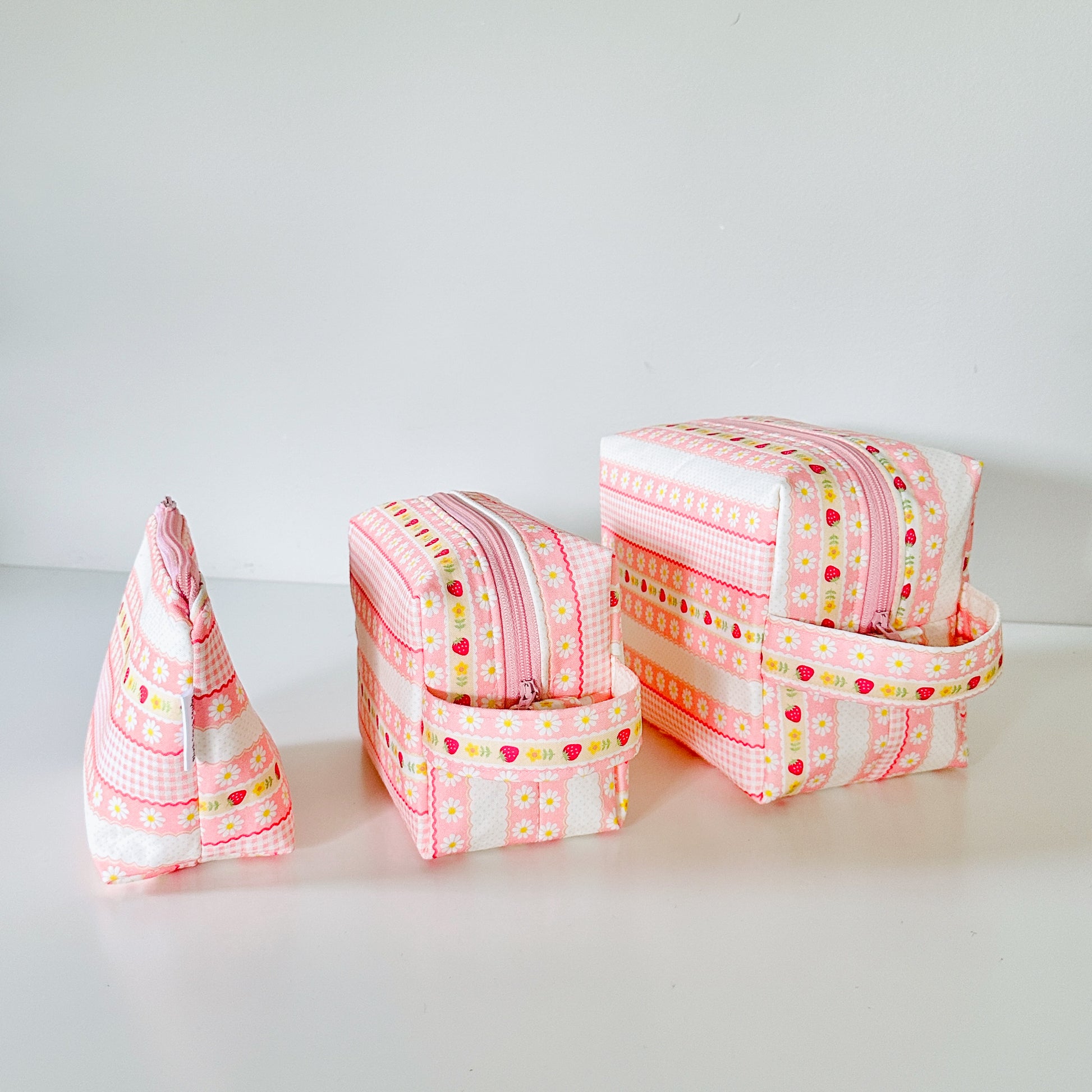 pink strawberry patterned makeup cosmetic bags on a white background