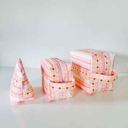 pink strawberry patterned makeup cosmetic bags on a white background