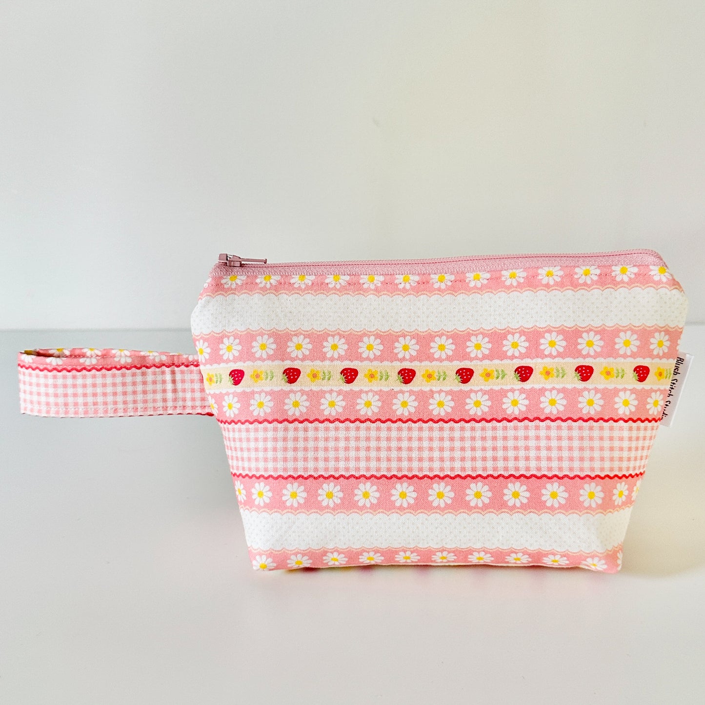 pink strawberry patterned makeup cosmetic bags on a white background
