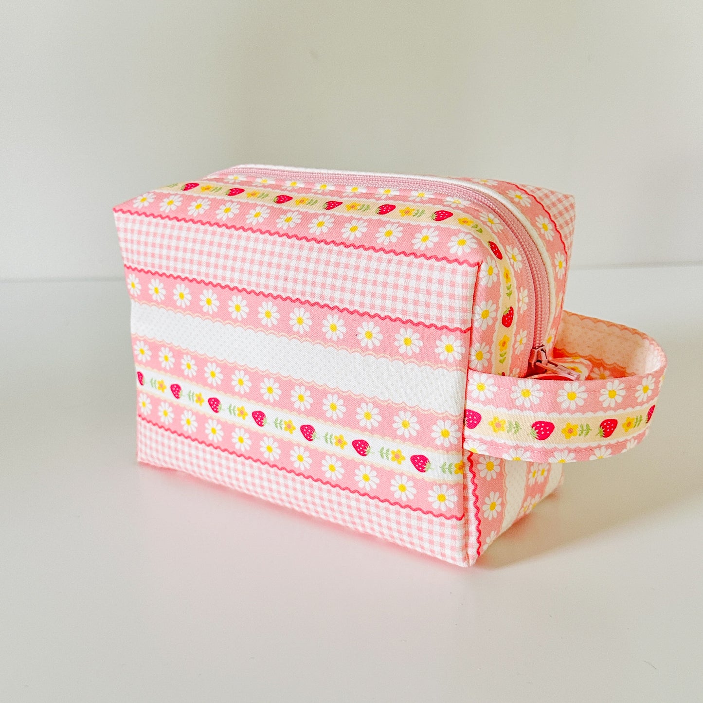 pink strawberry patterned makeup cosmetic bags on a white background