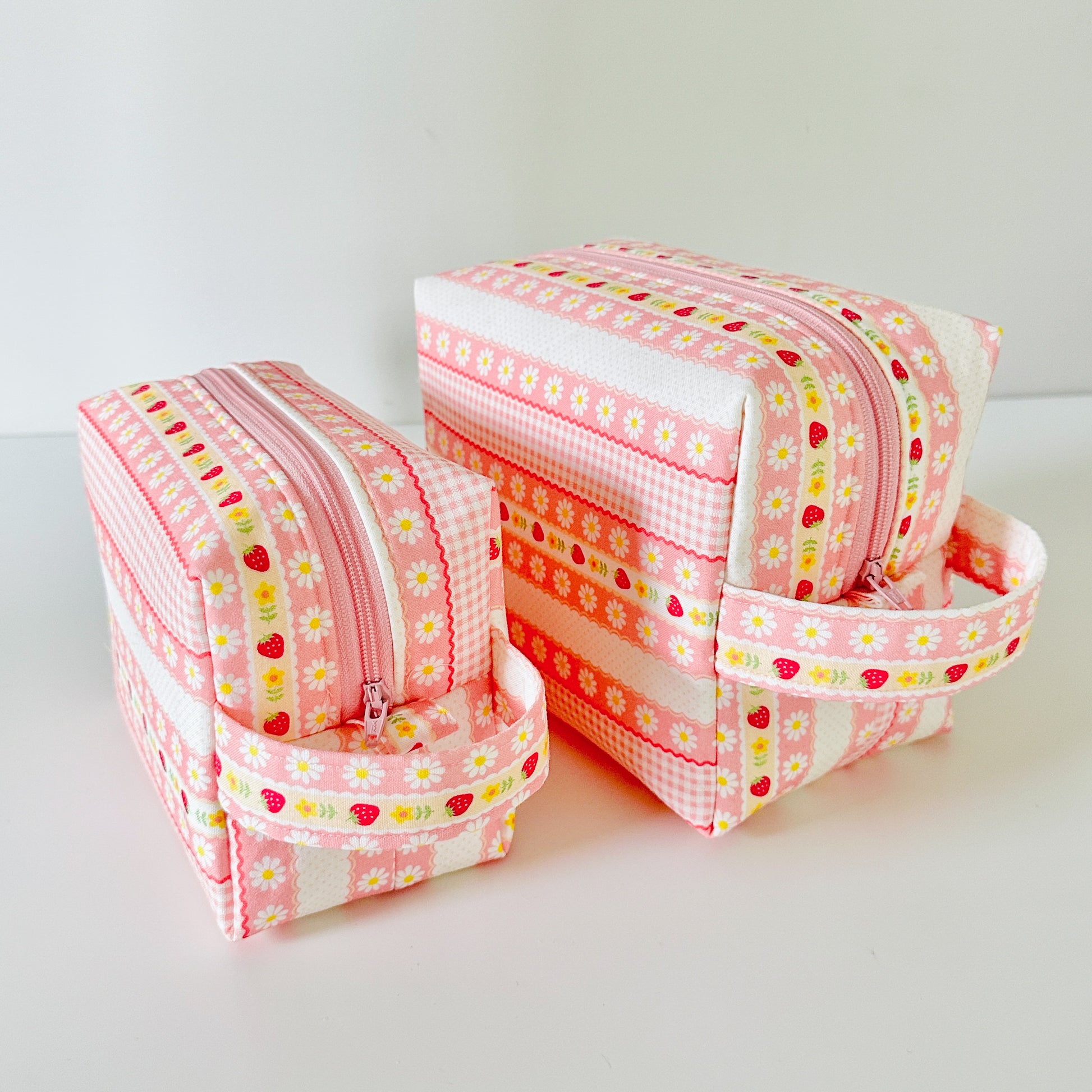 pink strawberry patterned makeup cosmetic bags on a white background