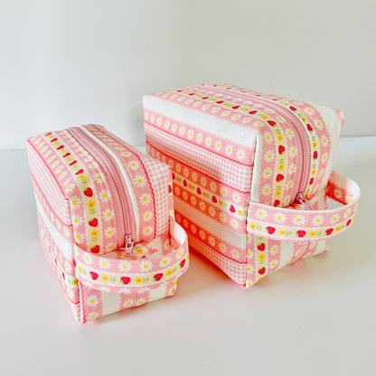 pink strawberry patterned makeup cosmetic bags on a white background