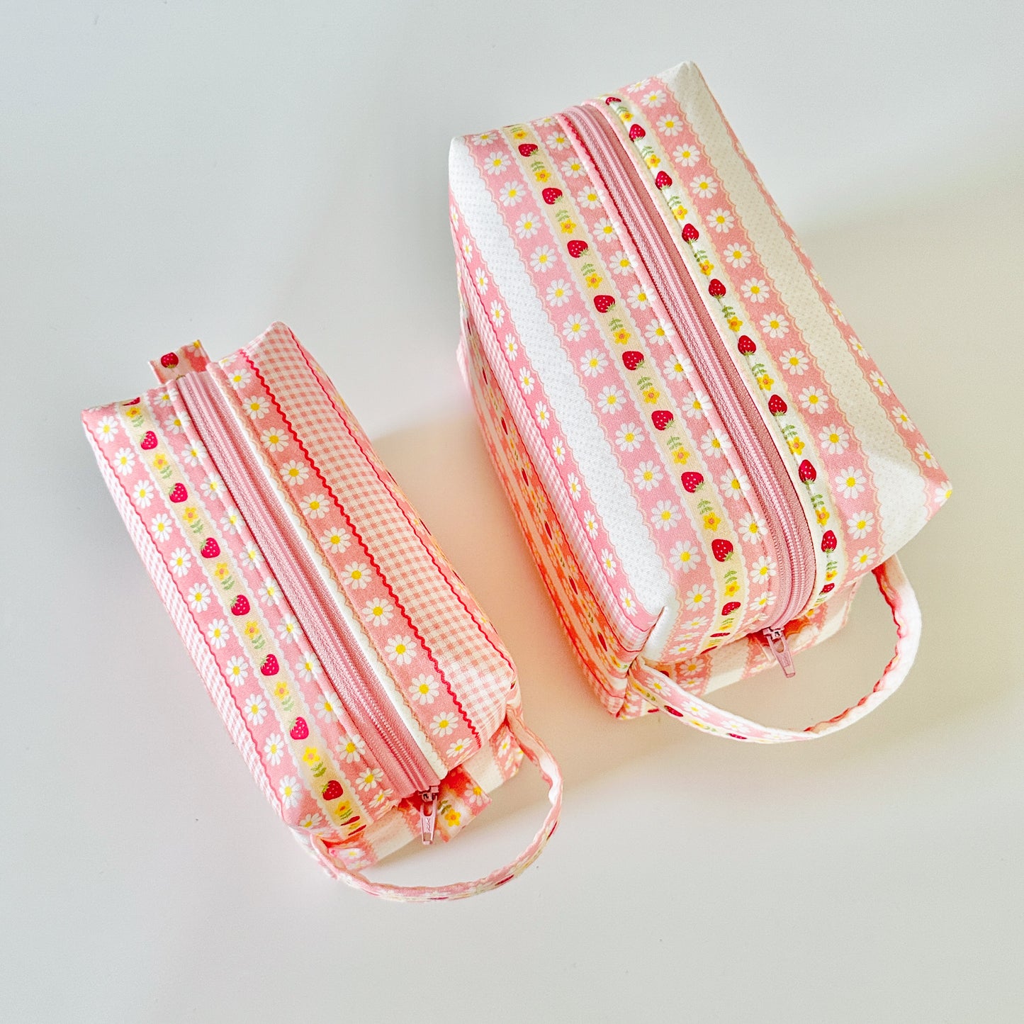 pink strawberry patterned makeup cosmetic bags on a white background
