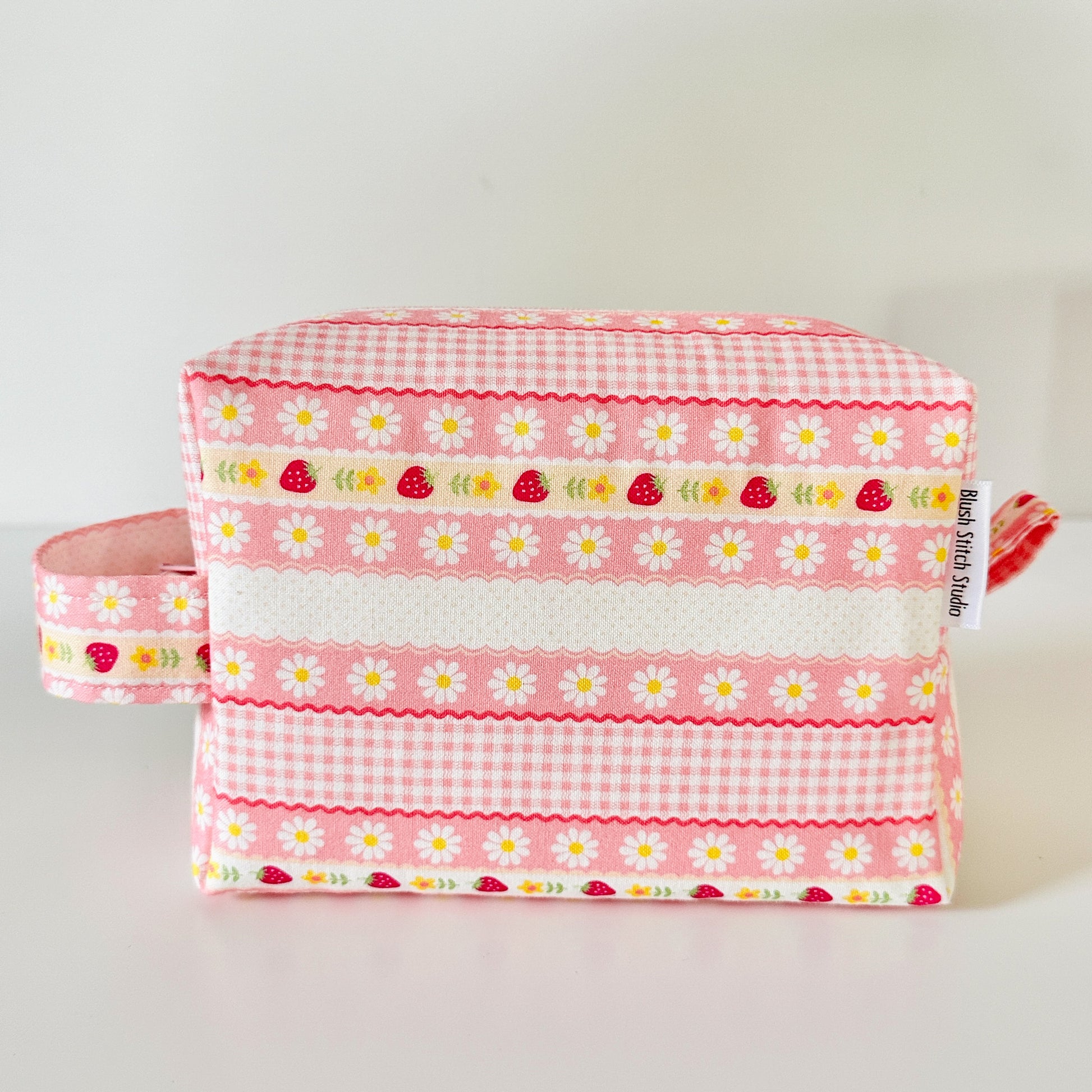 pink strawberry patterned makeup cosmetic bags on a white background