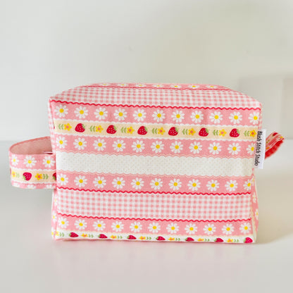pink strawberry patterned makeup cosmetic bags on a white background