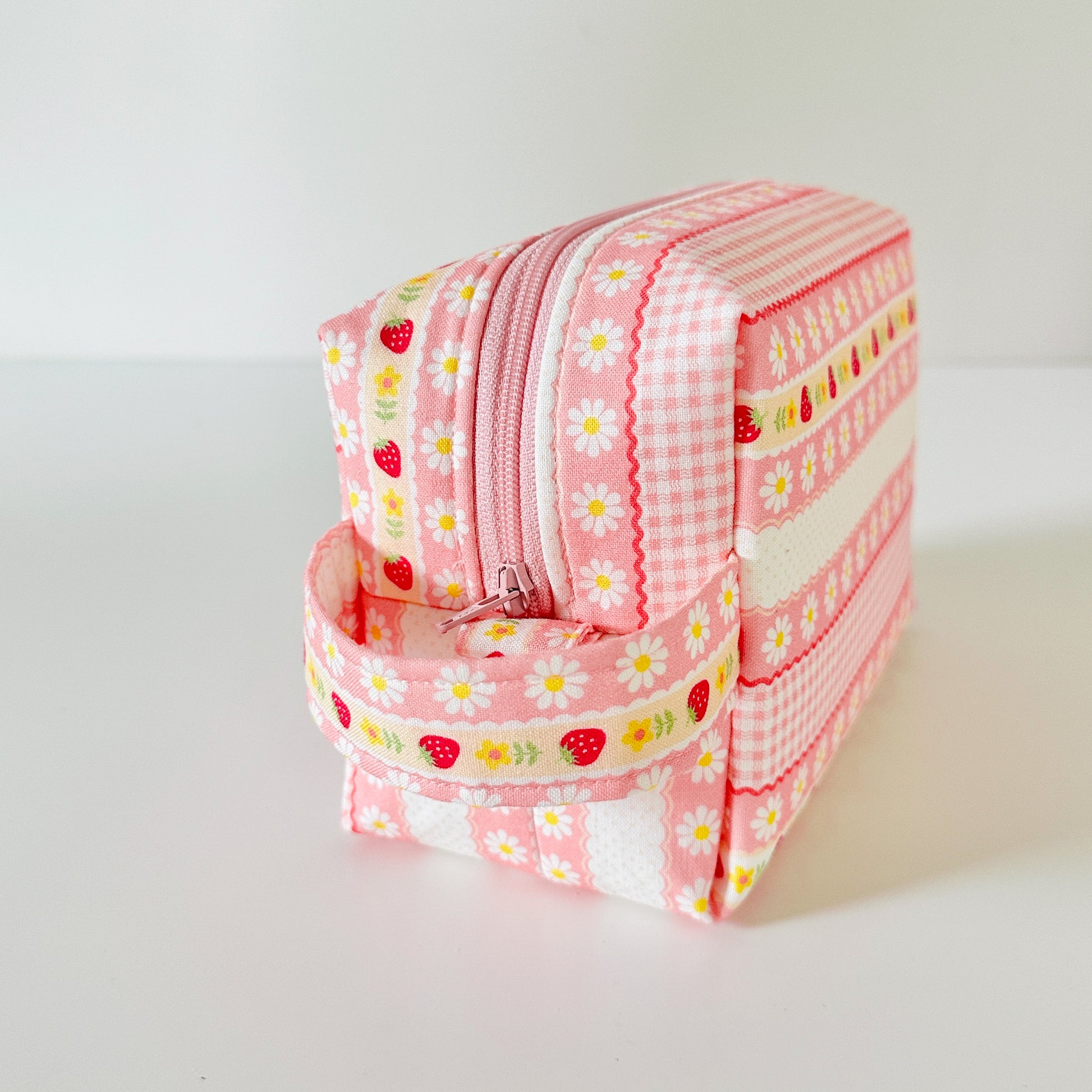 pink strawberry patterned makeup cosmetic bags on a white background