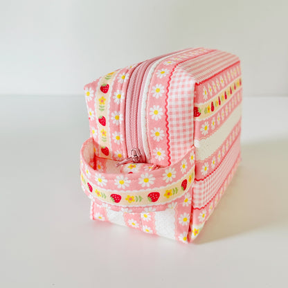 pink strawberry patterned makeup cosmetic bags on a white background