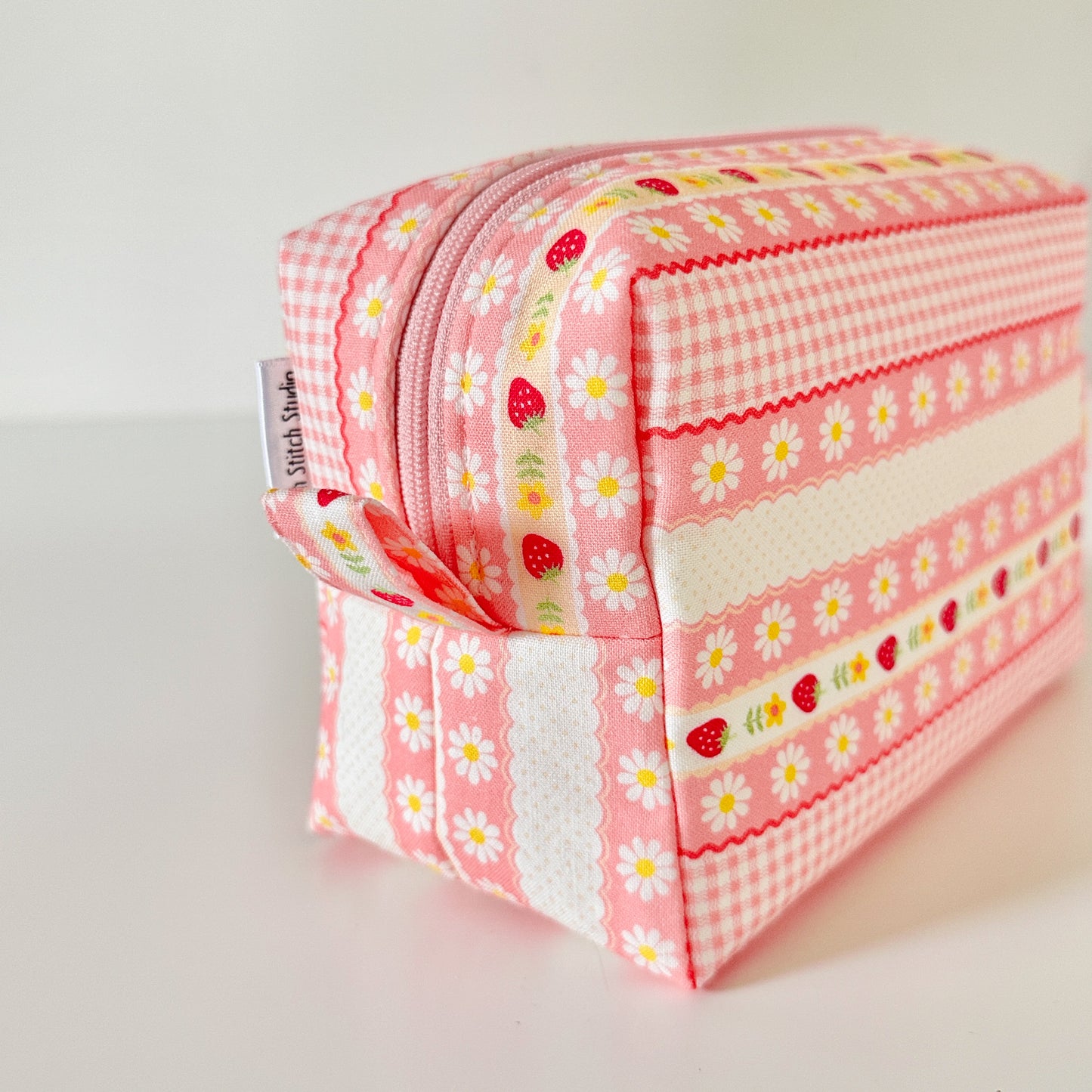 pink strawberry patterned makeup cosmetic bags on a white background