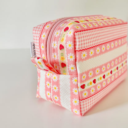 pink strawberry patterned makeup cosmetic bags on a white background