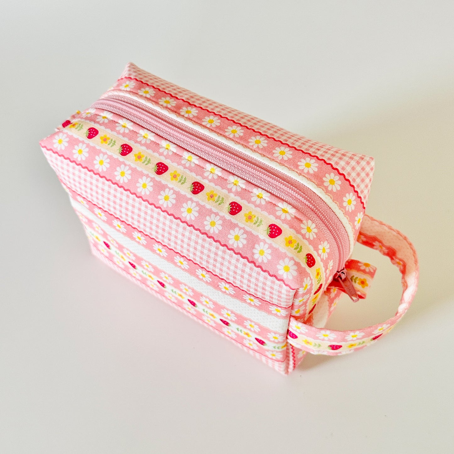 pink strawberry patterned makeup cosmetic bags on a white background