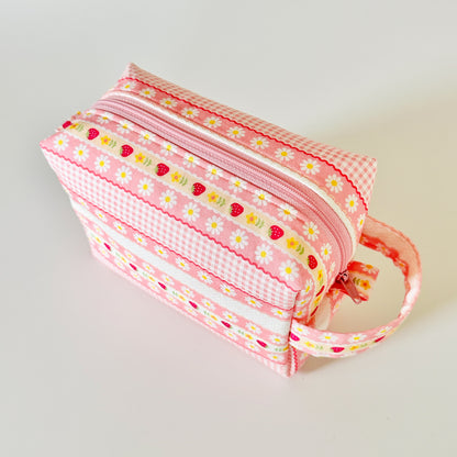 pink strawberry patterned makeup cosmetic bags on a white background