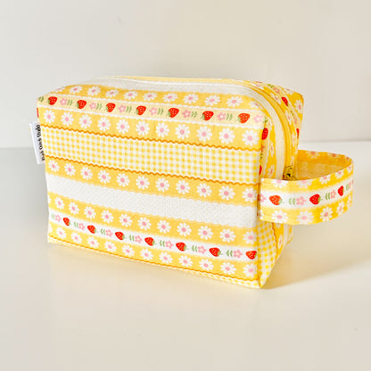 Yellow strawberry patterned bags on a white background