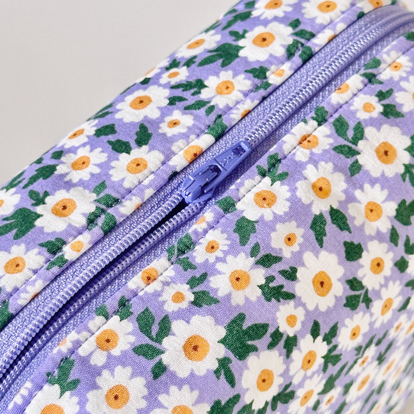Floral-patterned bag with a zipper on a light gray background