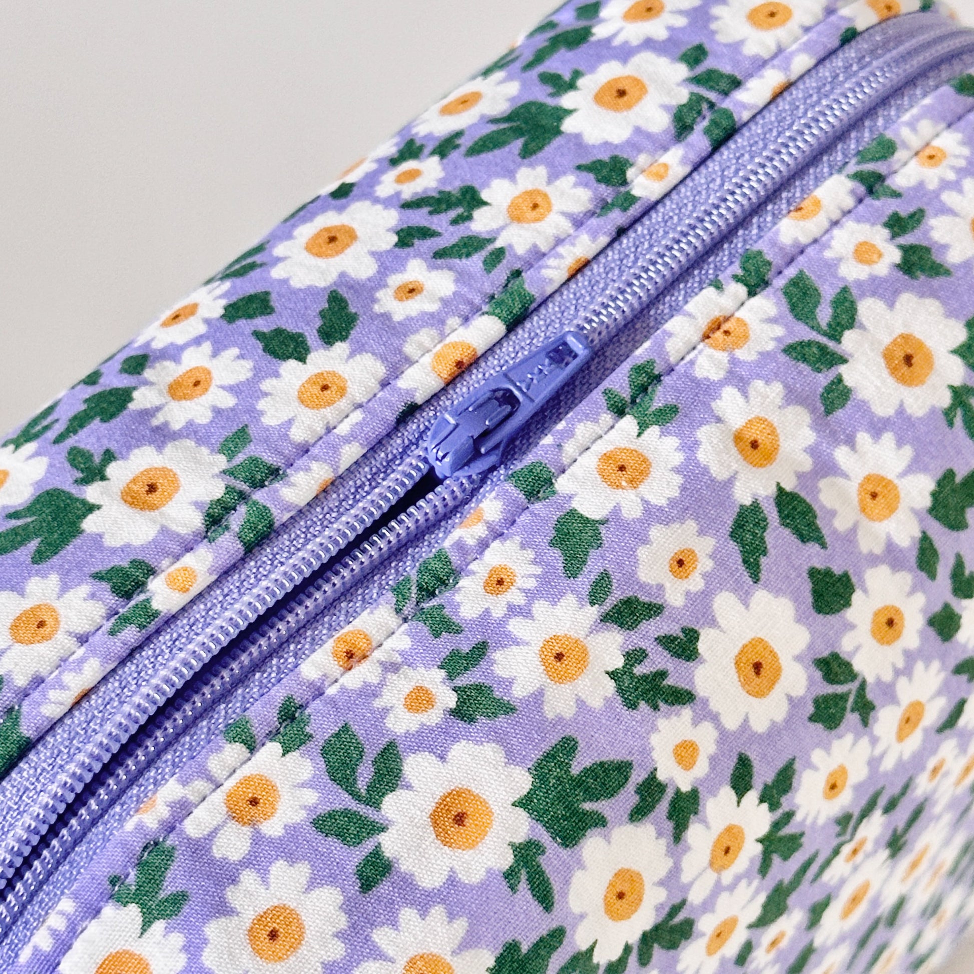 Floral-patterned bag with a zipper on a light gray background