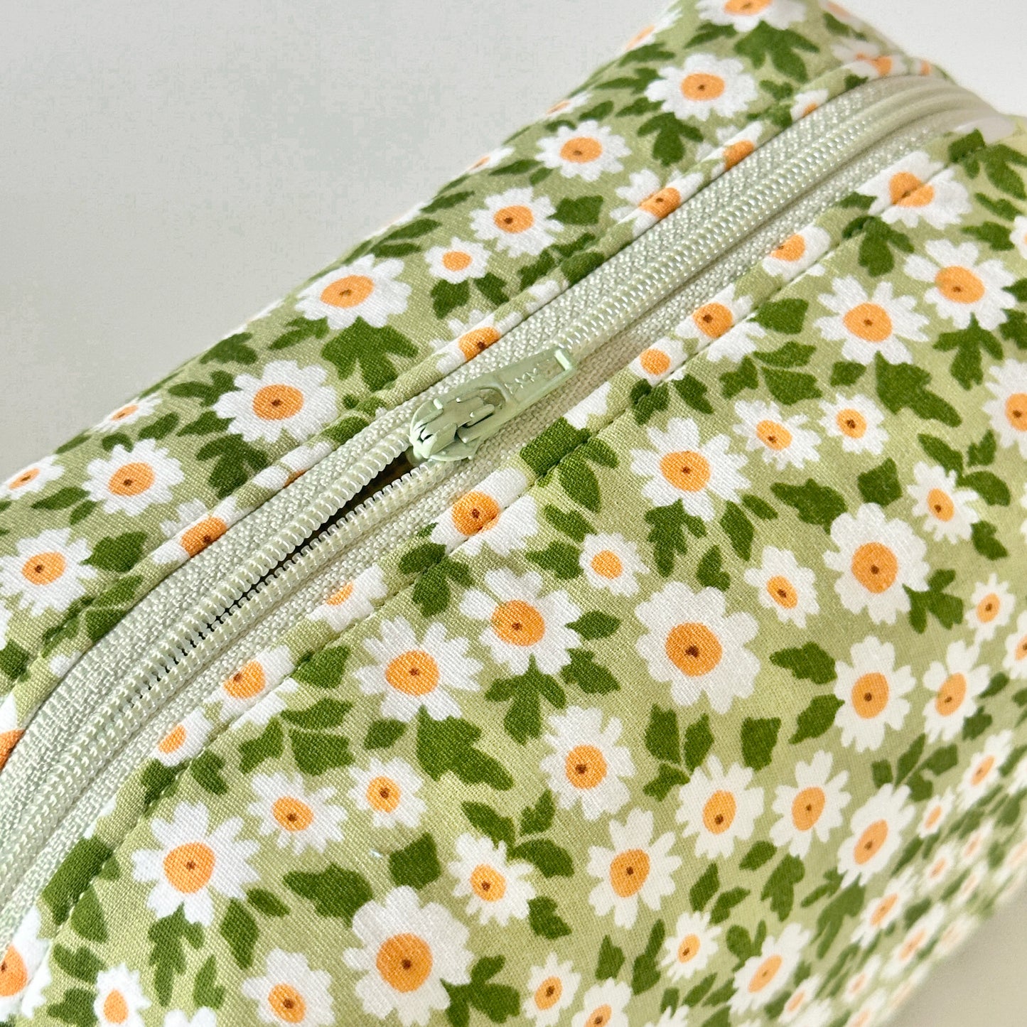 Floral-patterned pouch with a zipper on a light gray background