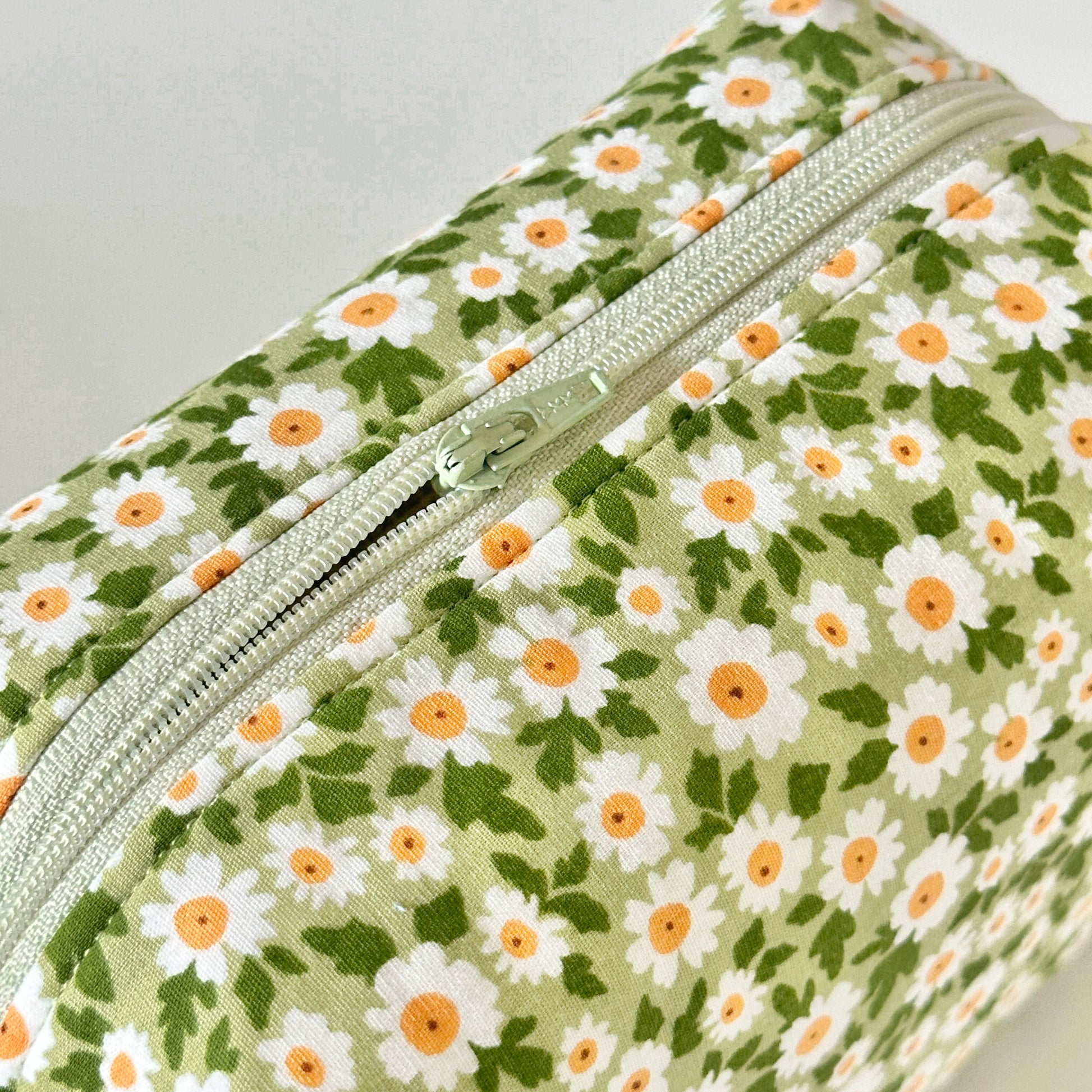 Floral-patterned pouch with a zipper on a light gray background