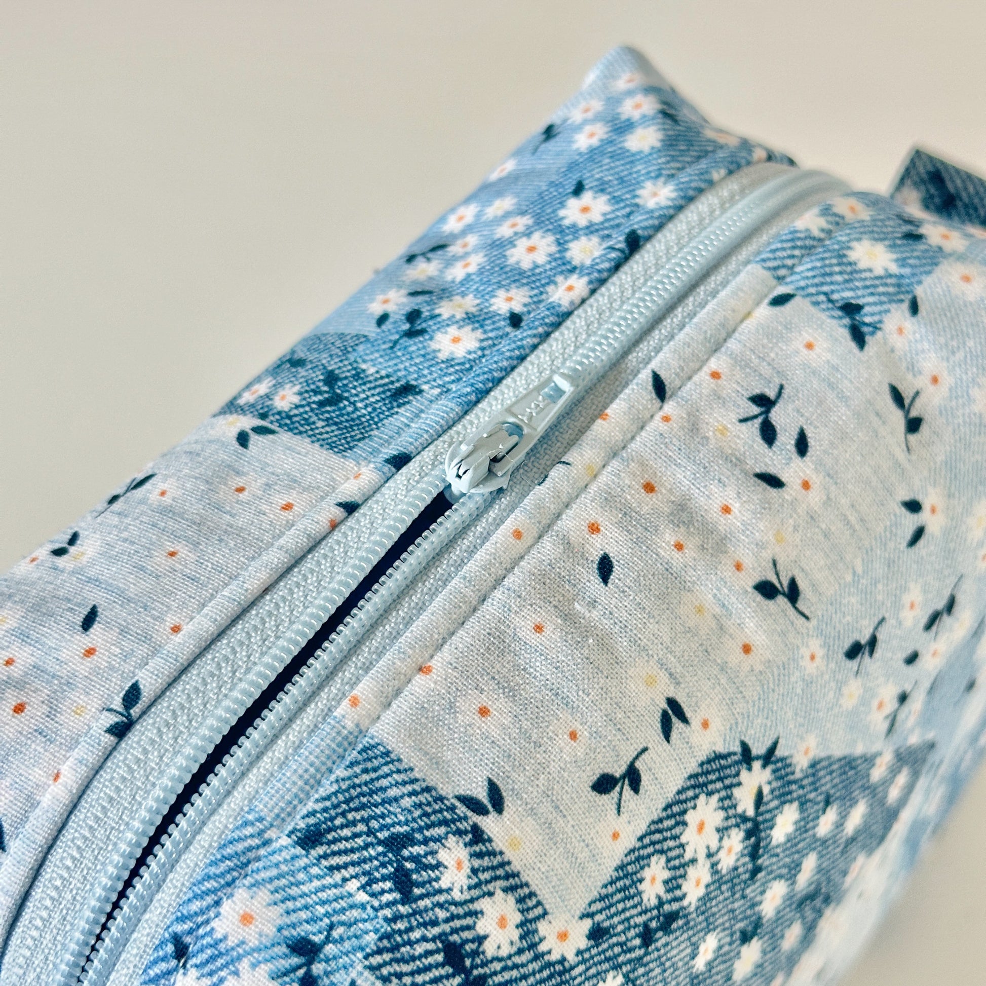 Three blue floral fabric pouches on a light background