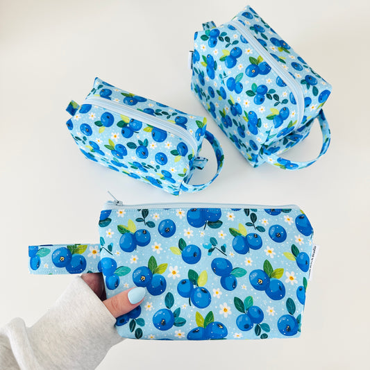 Set of blueberry-patterned makeup bag pouches on a white background
