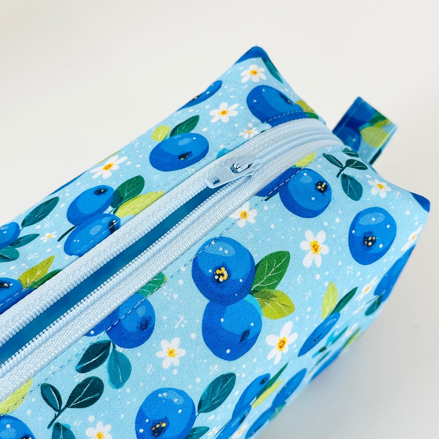 Fabric pouch with blueberry pattern on a light blue background