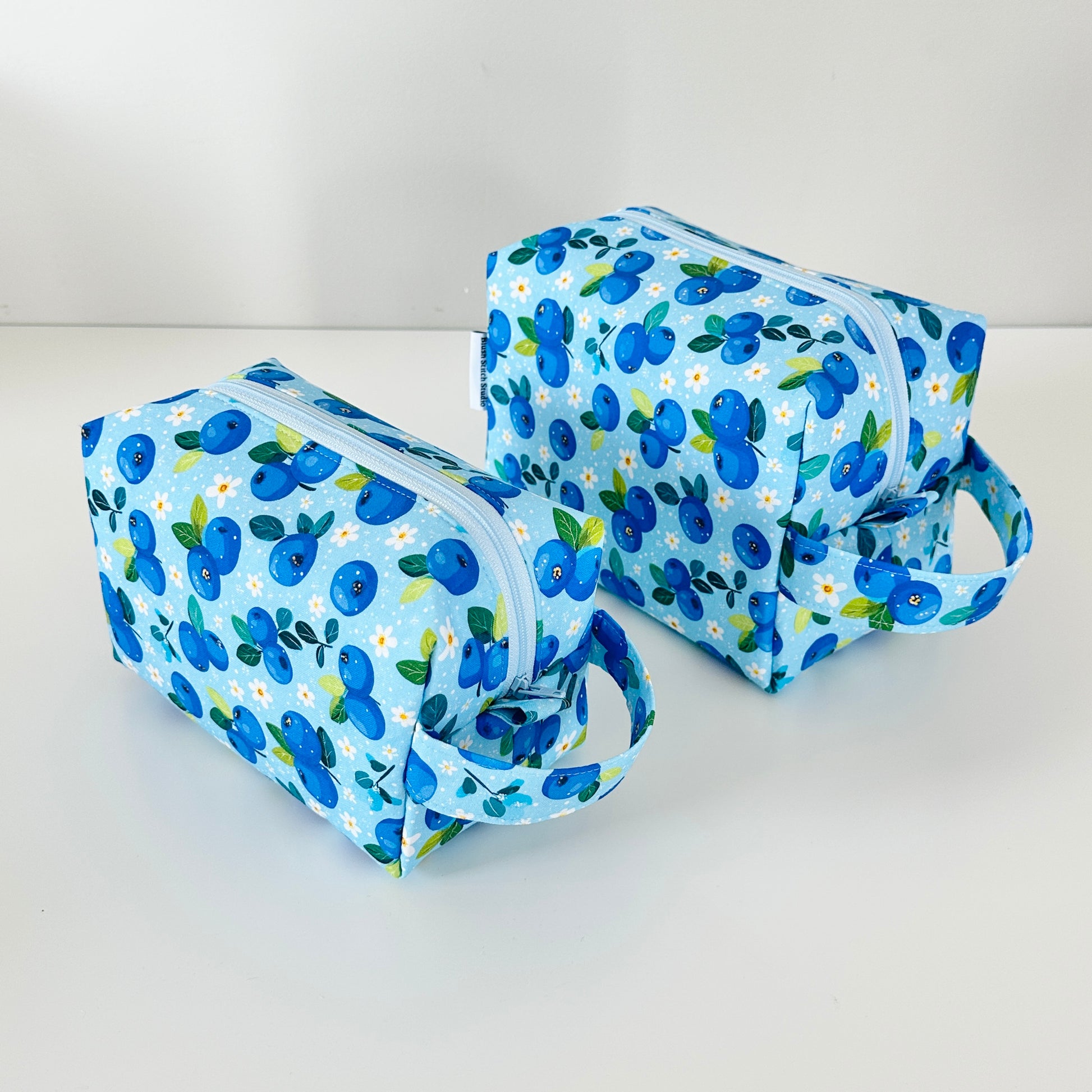 Two blue floral-patterned makeup bags on a white background