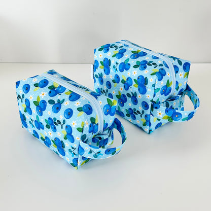 Two blue floral-patterned makeup bags on a white background