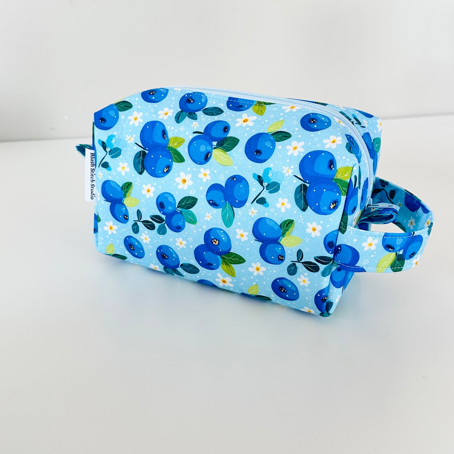 Blueberry-patterned toiletry bag on a white background