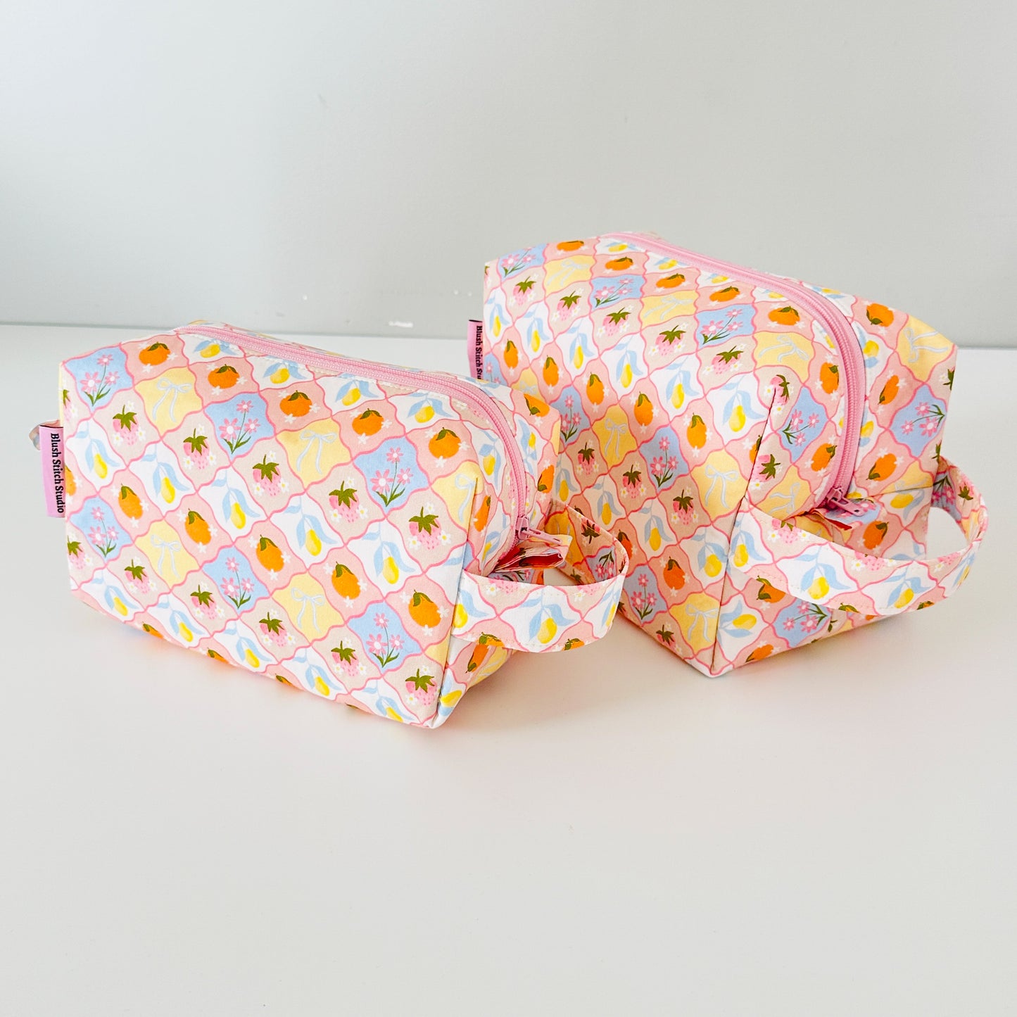 Two fruit patterned makeup bags with pineapple pattern on a white background