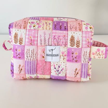 Patchwork pouch with floral patterns on a light gray background