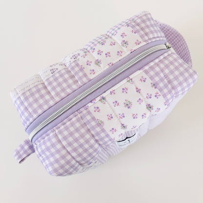 Patchwork pouch with floral and gingham patterns on a light background