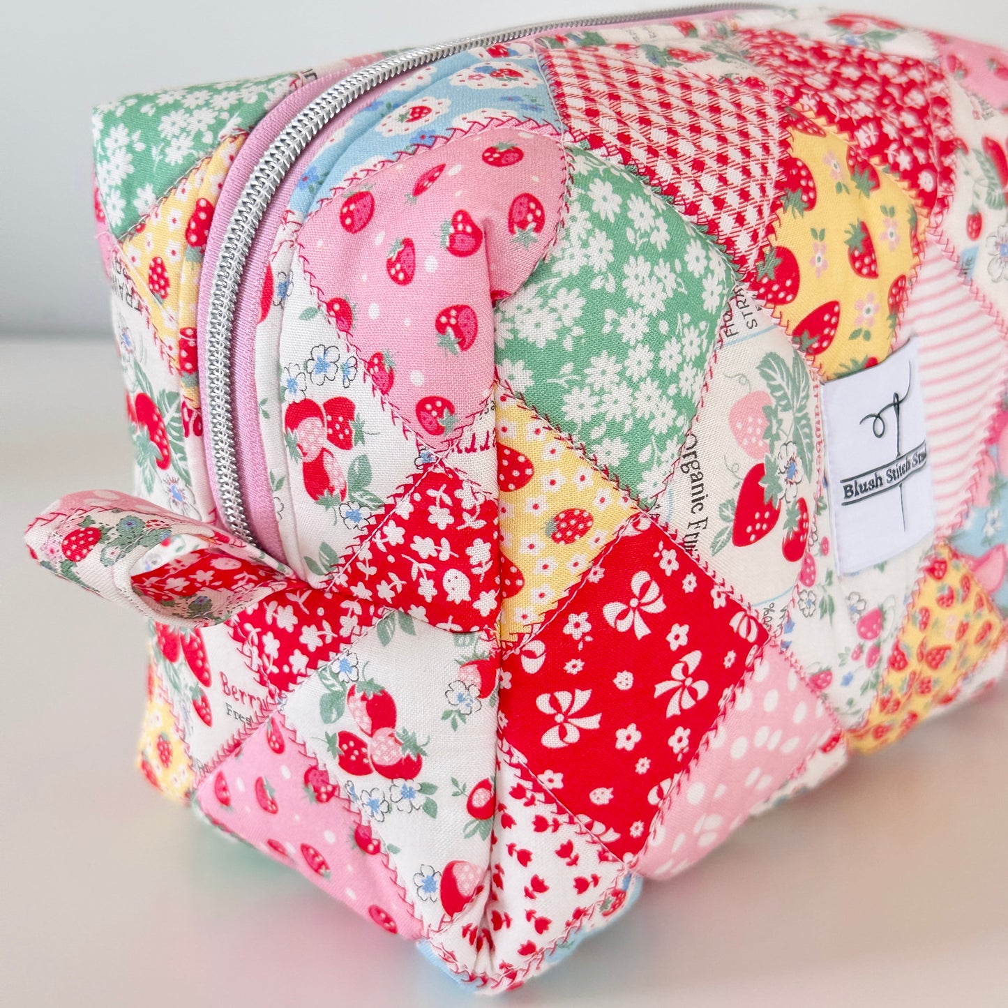 Patchwork-style cosmetic bag with colorful patterns on a light background
