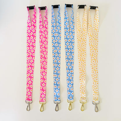 Four floral-patterned lanyards in pink, blue, and yellow on a white background