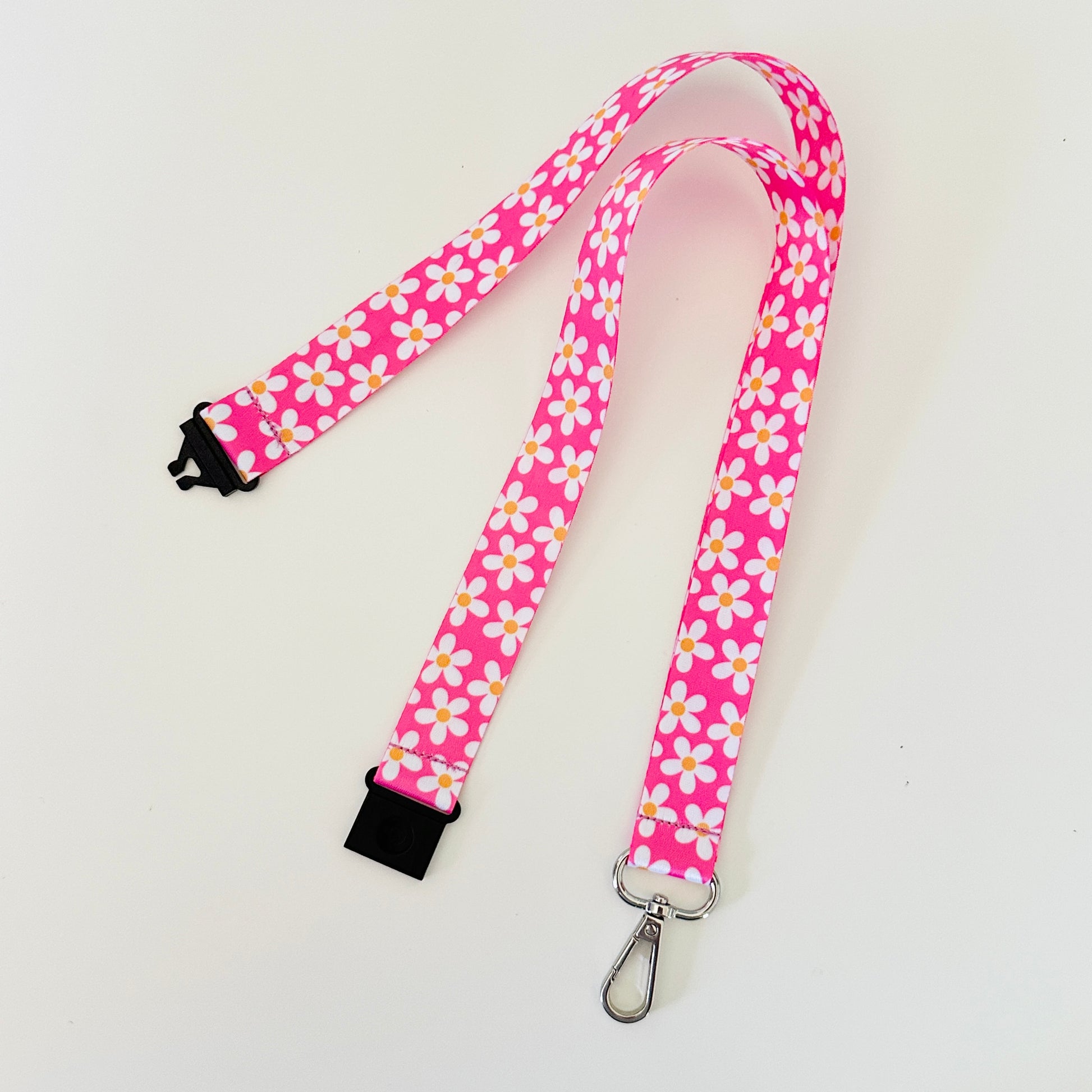 Pink lanyard with floral daisy pattern on a white background