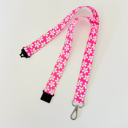 Pink lanyard with floral daisy pattern on a white background