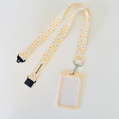 yellow daisy floral lanyard with a matching ID holder on a light gray background