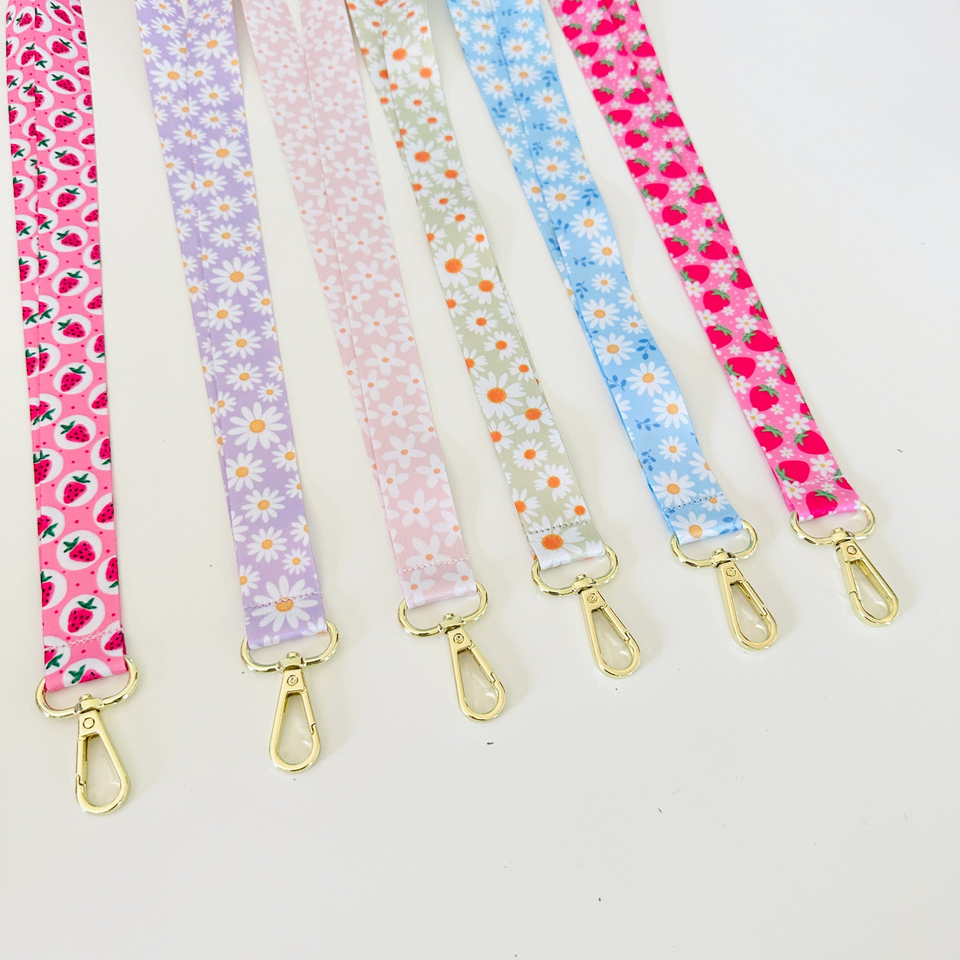 Set of floral patterned lanyards with gold clasps on a white background