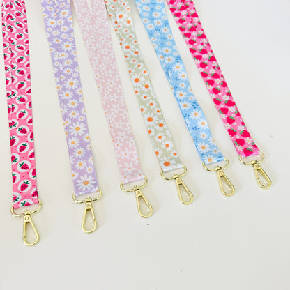 Set of floral patterned lanyards with gold clasps on a white background