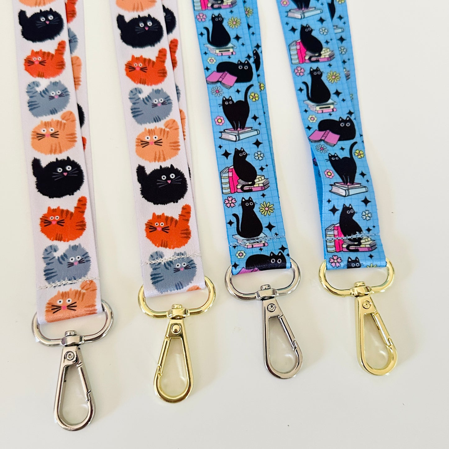 Four lanyards with cat patterns on a white background